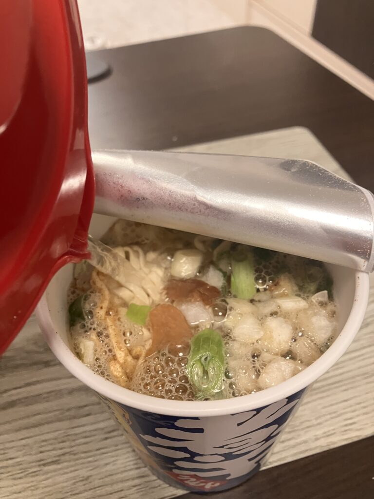 An image of hot water being poured into a Cup Noodles