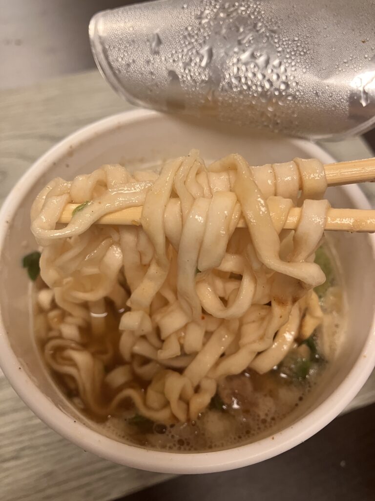 An image of lifting Cup Noodles with chopsticks