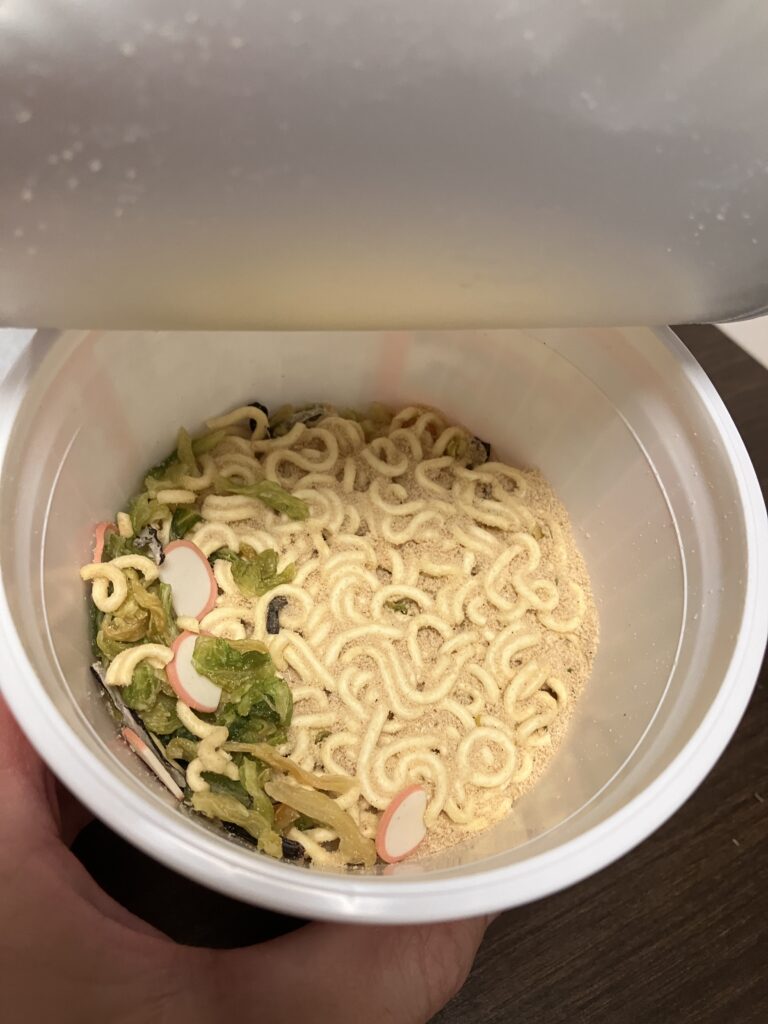 A photo of the contents of a cup noodle with the lid open