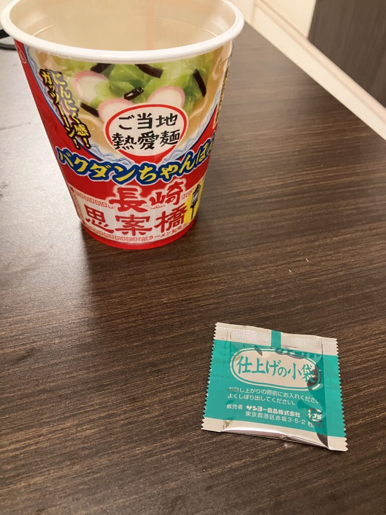A photo of the sauce being removed from the cup noodle