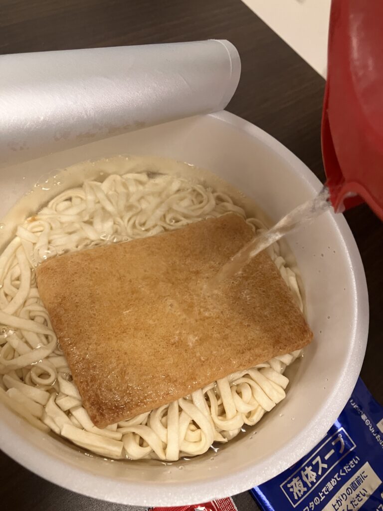 Photo of pouring hot water into a cup ramen