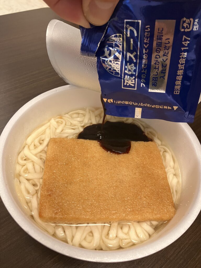 Photo of pouring soup into a cup ramen