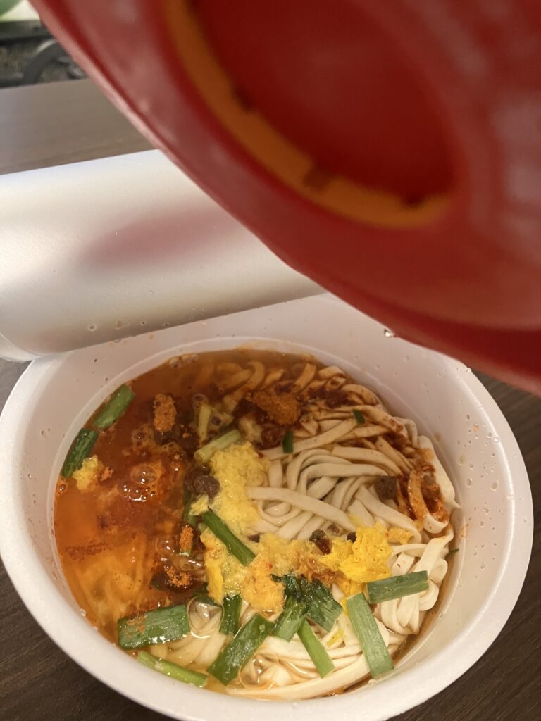 Photo of pouring hot water into cup ramen